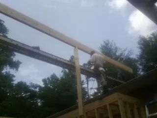 Carpenter setting a ridge beam over a new addition frame — Ice Dam Removal by Roofing Brothers in Elliott