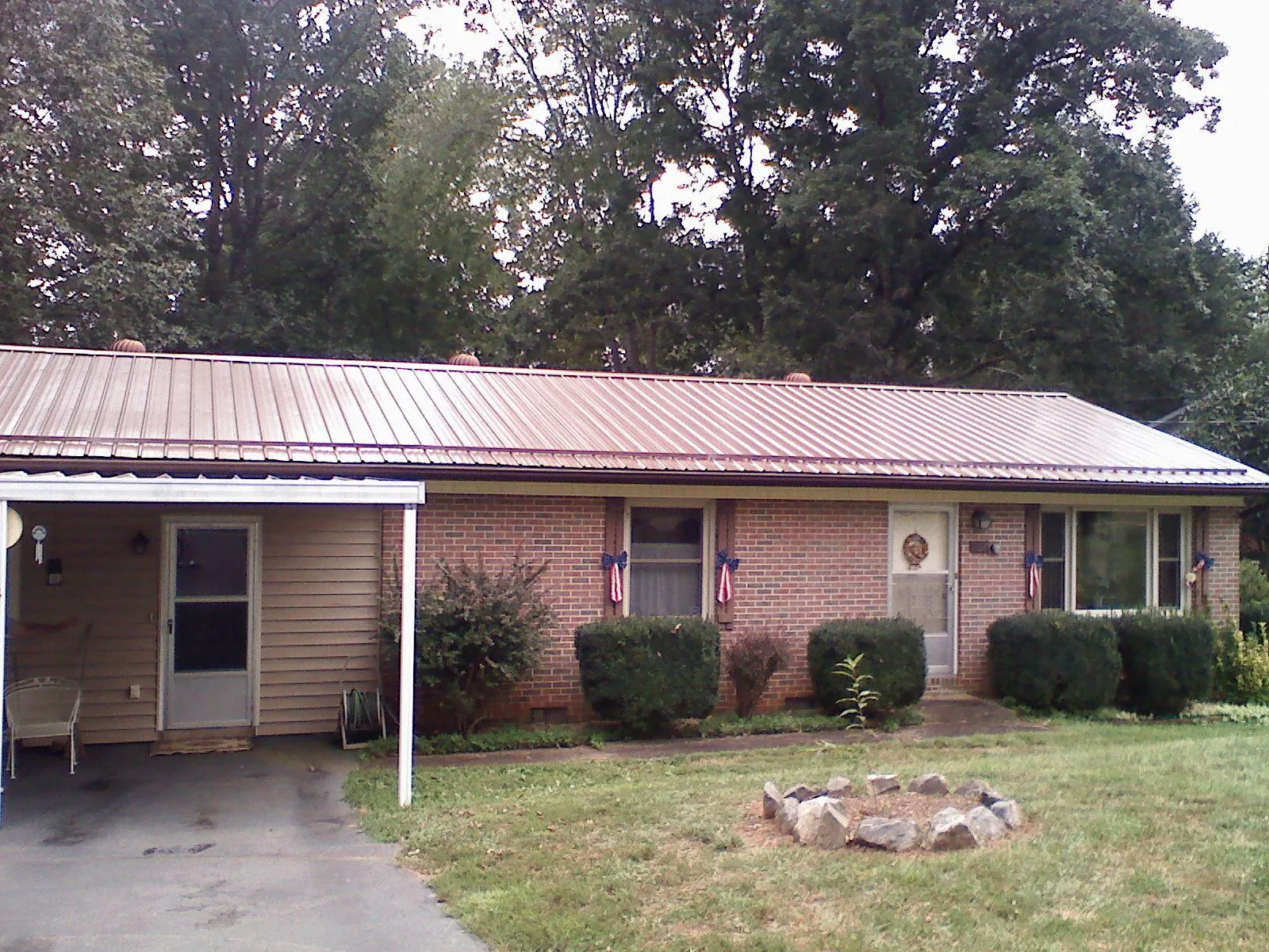 Bronze metal roof and carport on a brick ranch home — Roof Repair work by our crew in Elliott